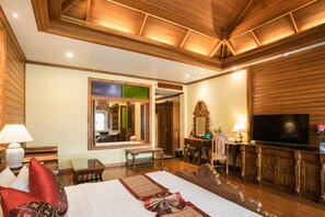 A hotel room with a large bed, a television, a desk, and a mirror. - Pingviman Hotel (Chiang Mai)