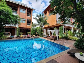Una piscina al aire libre, sillones reclinables de piscina