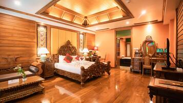 A spacious bedroom with a large bed, wooden furniture, and a ceiling with a skylight.
