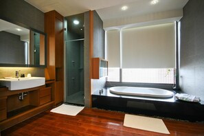 A modern bathroom with a large mirror, a sink, a bathtub, and a shower.