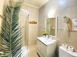 Habitación cuádruple básica | Baño | Ducha, secador de pelo, toallas y jabón