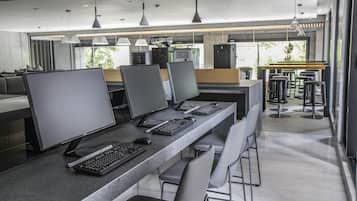 Um espaço de escritório moderno com várias estações de trabalho, cada uma equipada com monitor, teclado e rato.