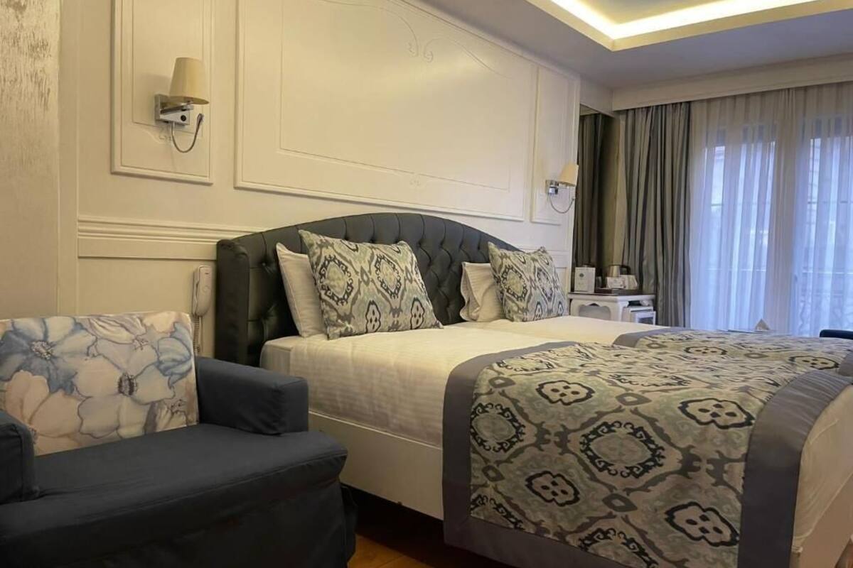 Ein Hotelzimmer mit Bett, Sofa, Nachttisch und Lampe.