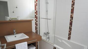 Une salle de bain avec un lavabo blanc, un miroir et une douche.