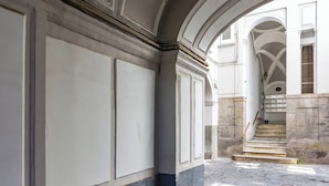 An arched corridor with stone flooring and white walls. - Cavour Art and Museum Flat by Napoliapartments (Naples)