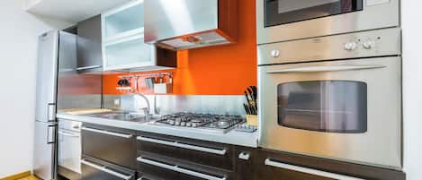 A modern kitchen with stainless steel appliances, a gas stove, and a built-in oven.