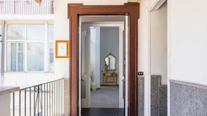 A hotel entrance with a brown door frame, a welcome mat, and a view into the interior.