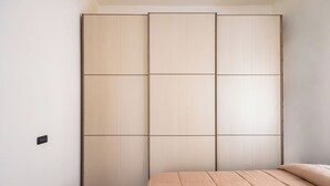 A bedroom with a bed, a wardrobe, and a wall socket. - Revolutionary Apartment Near Duomo Station (Naples)