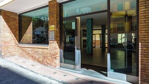 Une entrée moderne avec des portes en verre et une façade en briques.