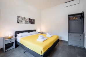 A neatly arranged hotel room with a bed, bedside tables, a wardrobe, and a painting on the wall. - Angelina Domus Saint Peter's (ROMA)