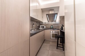 A modern kitchen with a microwave, stove, and sink.