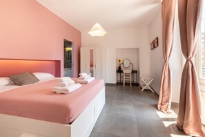 A modern hotel room with a bed, a desk, and a chair.