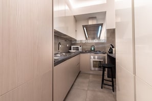 A modern kitchen with a microwave, stove, and sink.