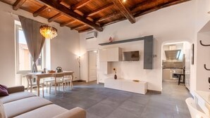 A modern interior with a dining area, sofa, and kitchen.