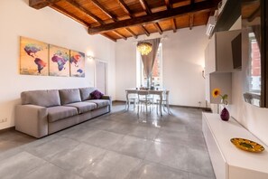 A modern living room with a sofa, dining table, and artwork on the wall. - Angelina Domus Saint Peter's (ROMA)