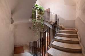 A spiral staircase with a metal railing and a plant-covered landing. - Angelina Domus Saint Peter's (ROMA)