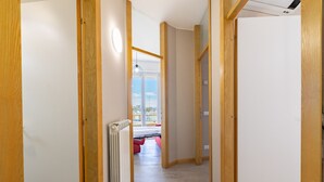 A narrow hallway with wooden doors and a radiator on the left.