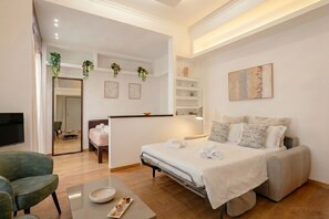 Een hotelkamer met een bed, een bureau, een stoel, een televisie en een spiegel.
