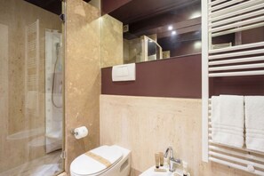 Een badkamer met toilet, wastafel en douche.