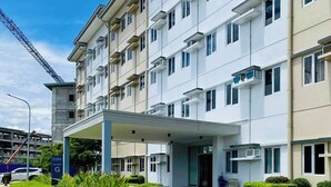 A multi-story hotel with a covered entrance and a parking area. - SMDC Park Residences Condo unit 417 near SM City of Santa Rosa Laguna (City of Santa Rosa)