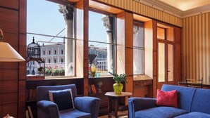 A room with a large window, two blue sofas, a small table with a potted plant, and a bookshelf. - Ca Dadda terrace at Rialto Bridge -historic residence equipped with all comforts (Venezia)