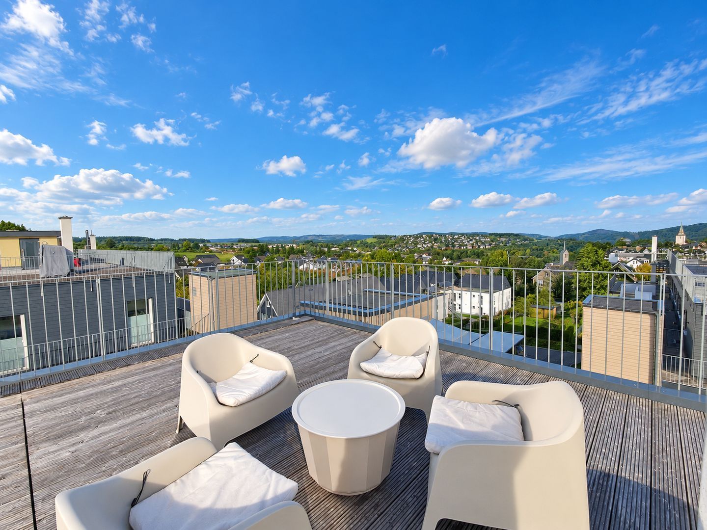 Une terrasse sur le toit, avec des sièges en plein air et une vue sur la ville.