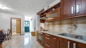 A modern kitchen with wooden cabinets, a stainless steel sink, and a tiled backsplash. - Amazing home in Rogoznica with WiFi (Rogoznica)