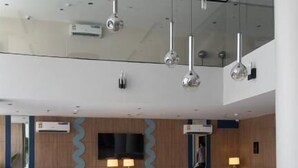 Eine moderne Lobby mit einer zentralen Sitzecke, einer Wasserspiele und zeitgemäßen Leuchten.