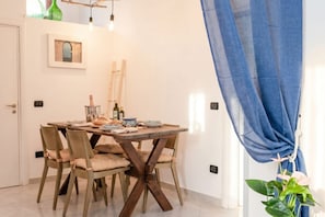 A dining area with a wooden table, beige chairs, and a blue curtain.