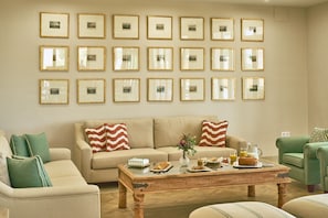 A living room with a sofa, coffee table, and framed pictures on the wall. - Rural House 'Dehesa El Alcornocal' with Private Pool, Wi-Fi and Air Conditioning (Posadas)