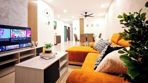 A modern living room with a TV, sofa, and ceiling fans.