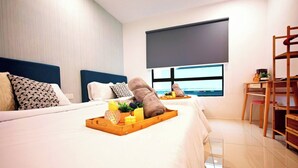 Ein modernes Hotelzimmer mit zwei Betten, einem großen Fenster, einem Schreibtisch und einem Sessel.