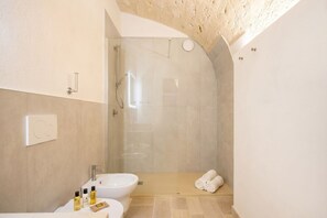 Een moderne badkamer met een douche, wastafel en toilet.