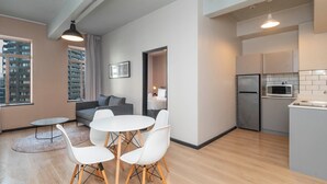 Un appartement moderne comprenant un coin repas, une cuisine et offrant une vue sur la ville.