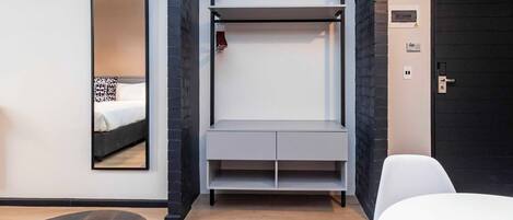Une chambre d’hôtel moderne équipée d’un lit, d’un bureau, d’une chaise et d’une armoire.
