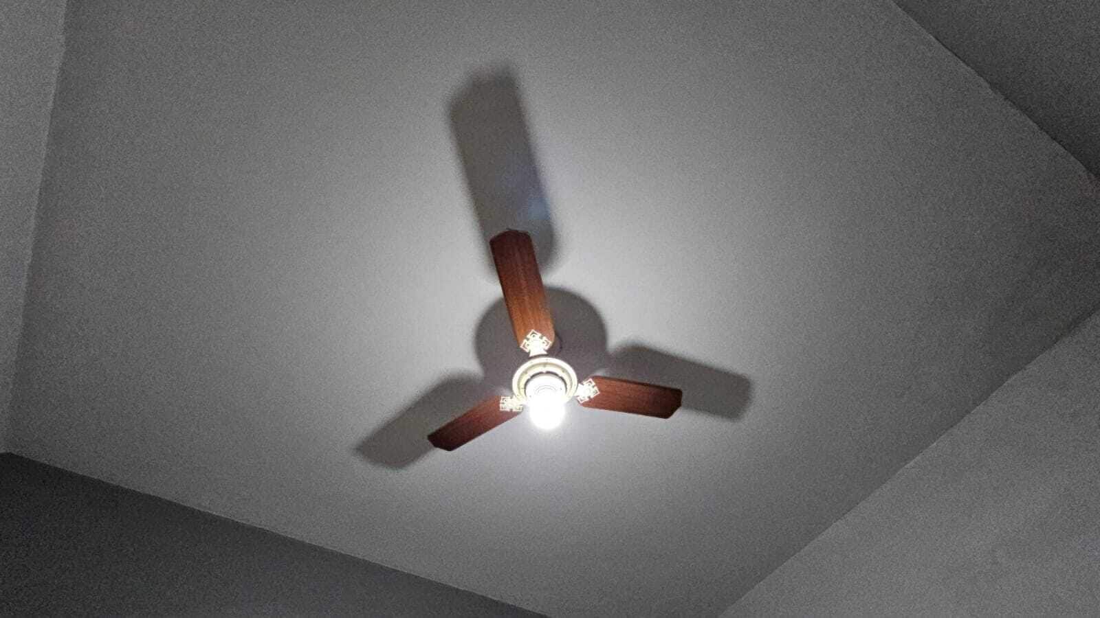 Un ventilador de techo con tres aspas y una lámpara.