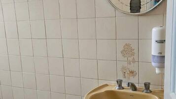 Un baño con inodoro, lavamanos y espejo.