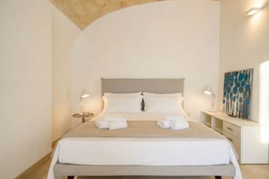 Una habitación de hotel con una cama, dos mesitas de noche y un cuadro en la pared.