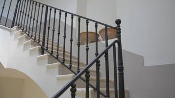 Una scala con balaustre nere e gradini color beige.
