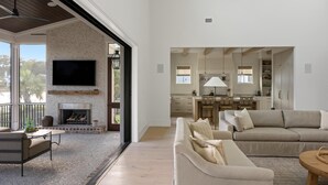 Un salón amplio con chimenea, un sofá y una mesa de comedor.