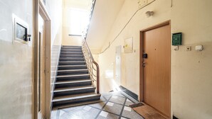 A staircase with a metal railing leading to a wooden door. - ShortStayPoland Józefitów C4 (Kraków)