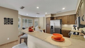 A modern kitchen with a central island, stainless steel appliances, and a view to the outside. - Yorkshire Glendale (Glendale)