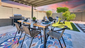 An outdoor patio with a grill, dining table, chairs, and a decorative rug. - Yorkshire Glendale (Glendale)
