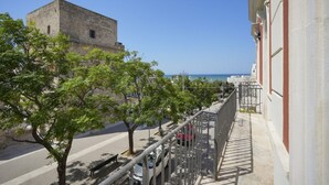 Un balcón con vistas a un edificio histórico y al mar.