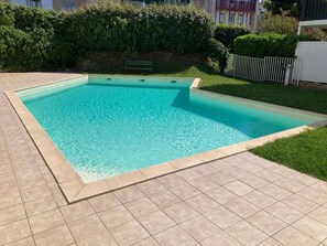 Ein rechteckiger Swimmingpool mit einer gefliesten Umrandung.