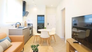 A modern apartment with a kitchen, dining area, and living room. - Modern apartment 5 min from the beach (Puerto de Sagunto)