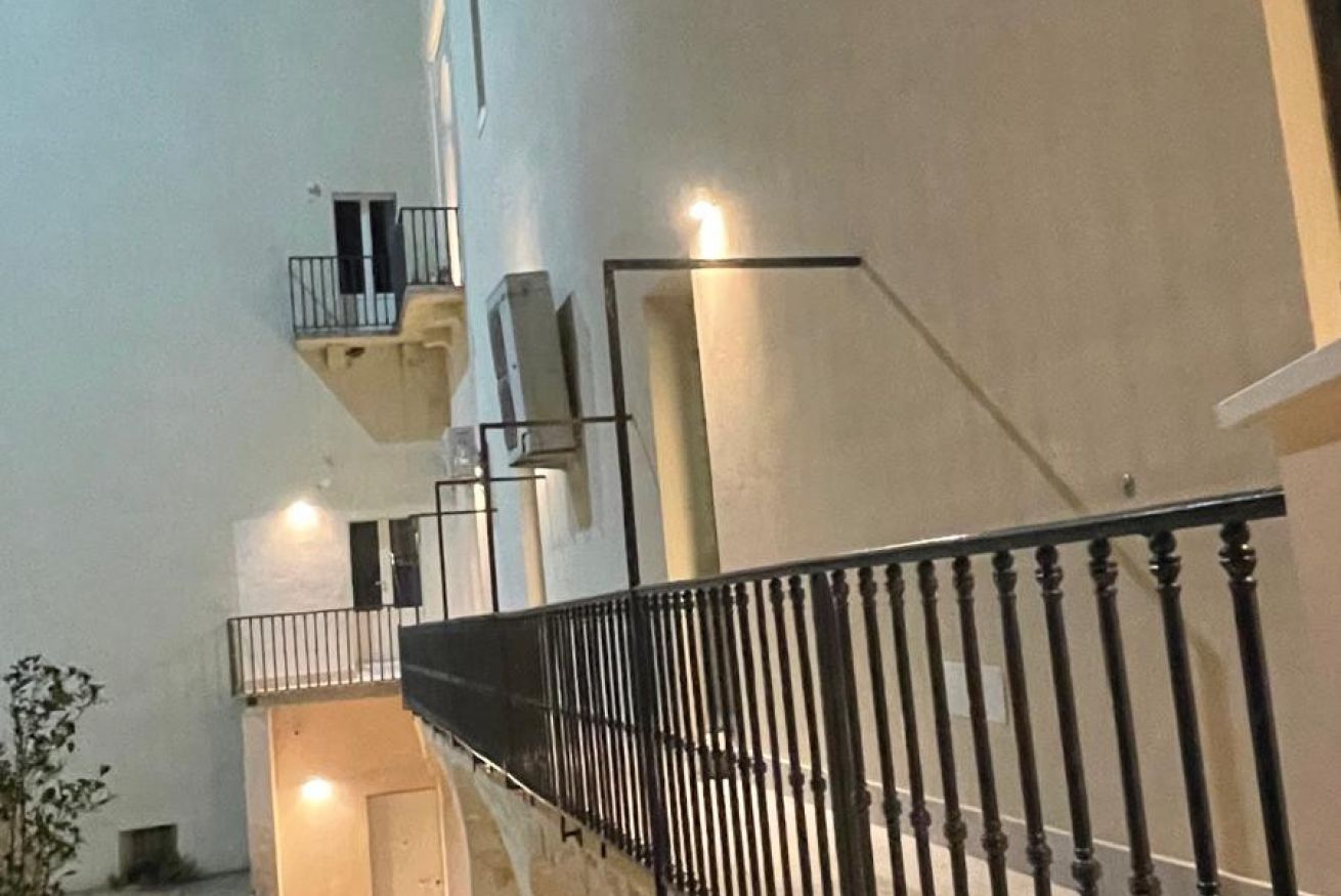 Ein mehrgeschossiges Interieur mit Treppe, Balkonen und Geländer.