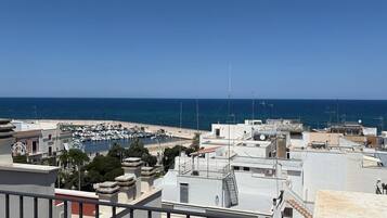 A coastal view with a marina, white buildings, and a clear blue sky.
