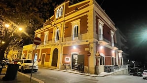 Un edificio histórico con un balcón y un restaurante en la planta baja.