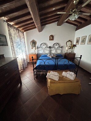Ein Schlafzimmer mit einem Bett, einem Holzschrank und einem Deckenventilator.